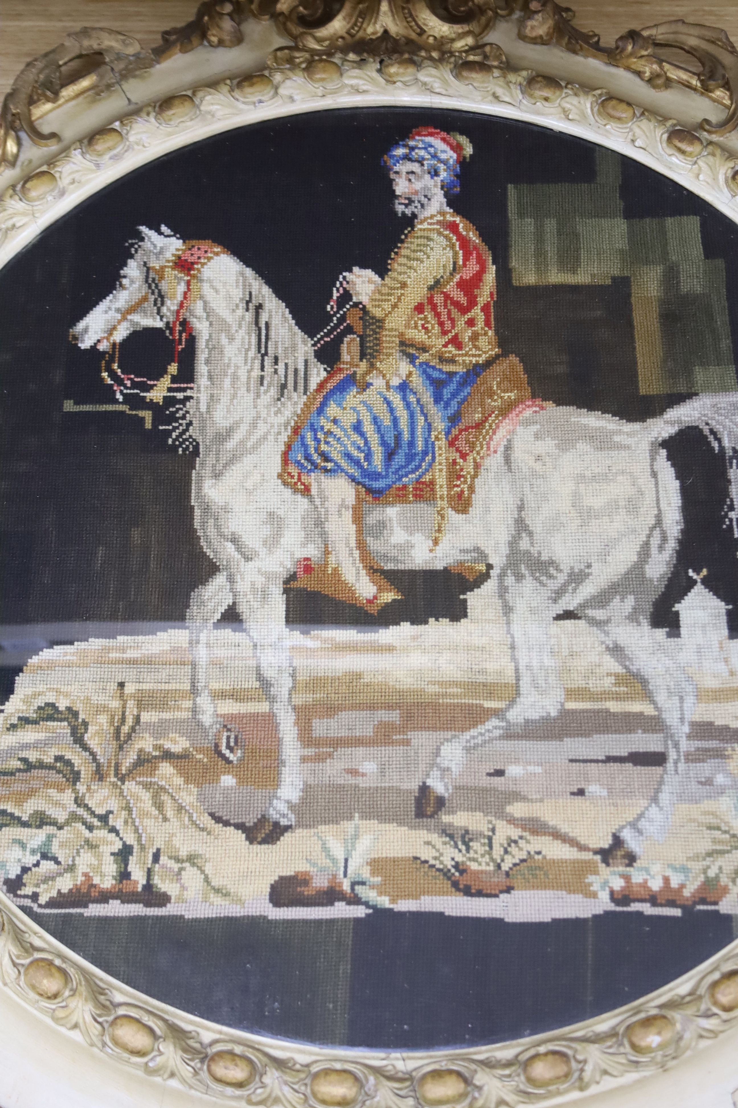 A 19th century Berlin woolwork panel of a horse and rider, framed, overall length 74cm